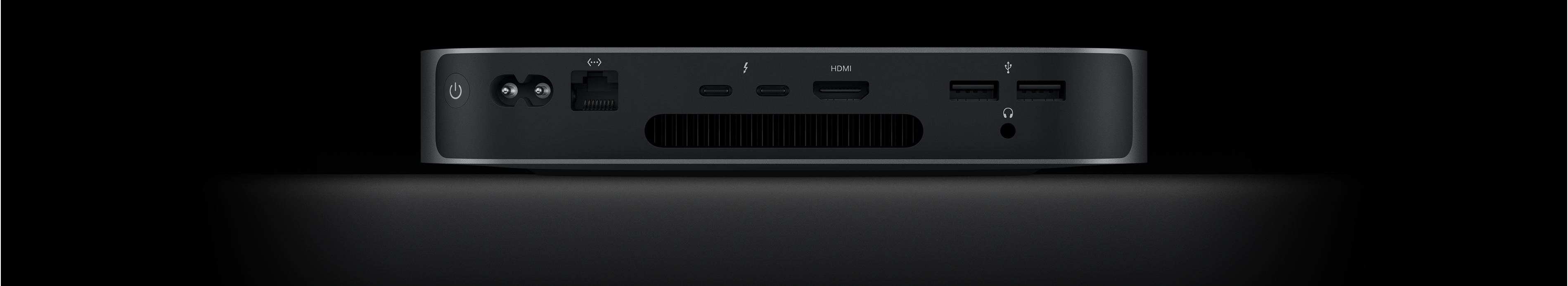Rückansicht des Mac mini, die die zwei Thunderbolt 4 Anschlüsse, den HDMI Anschluss, zwei USB‑A Anschlüsse, den Kopfhöreranschluss, den Gigabit Ethernet Anschluss, den Netzeingang und den Ein‑/Ausschalter zeigt.